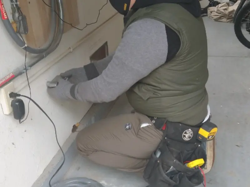 Electrician performing outlet wiring in a Burien garage